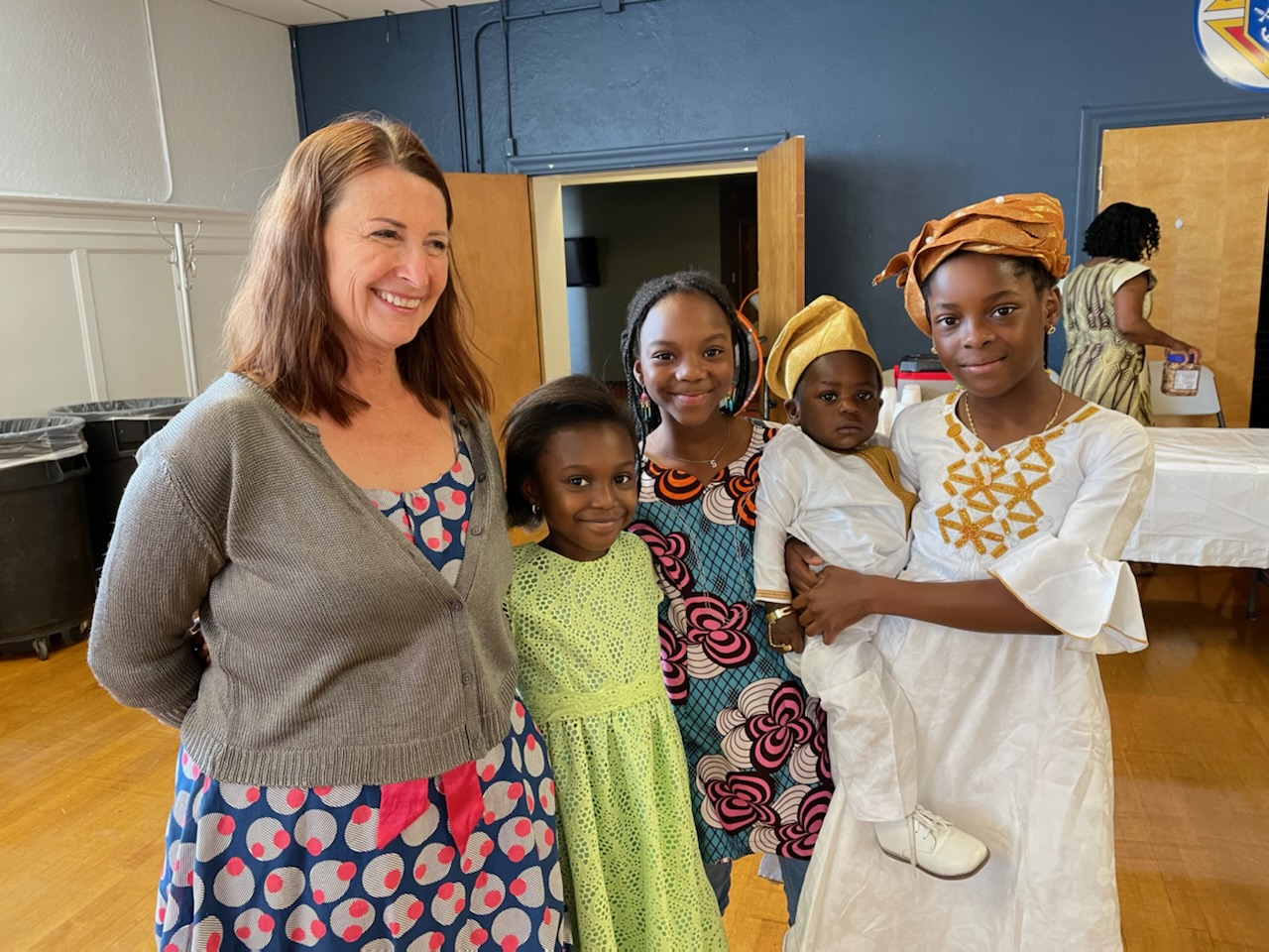 Kelly smiling with participants of the Beninese Camp including three Beninese children and an adult